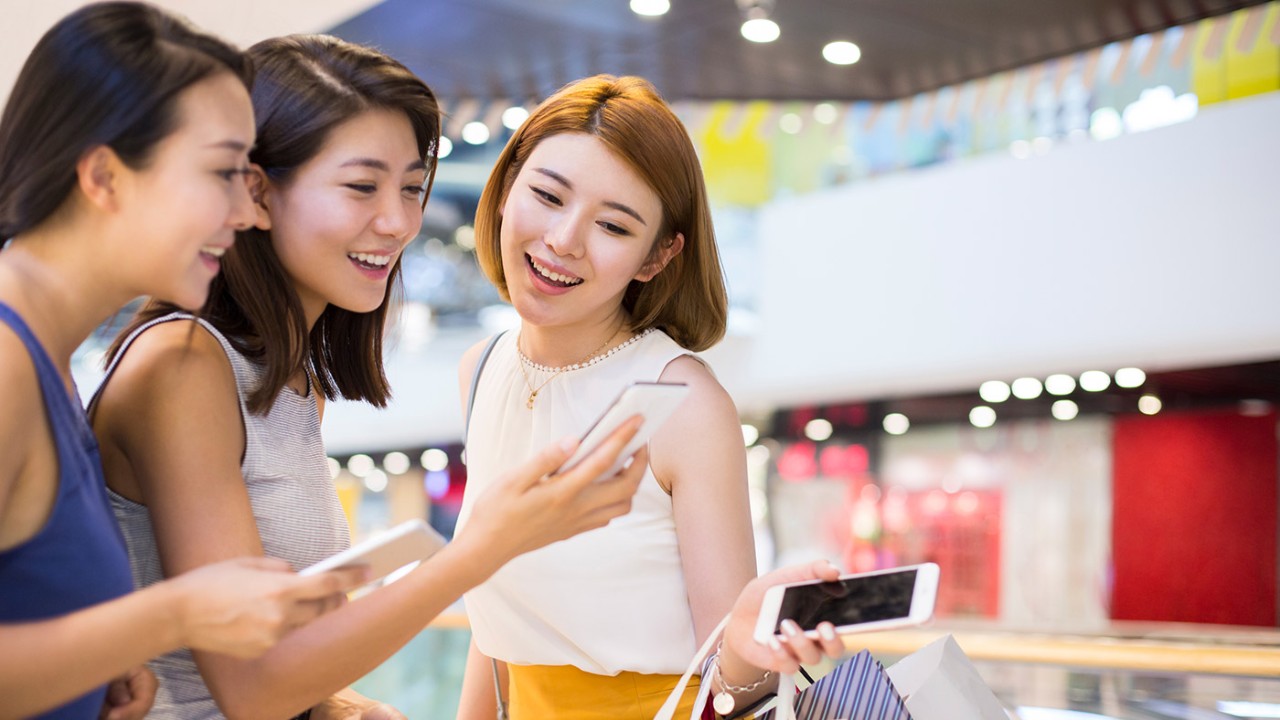 Girl friends laughing and looking at phone; image used for HSBC Philippines Visa Offers page